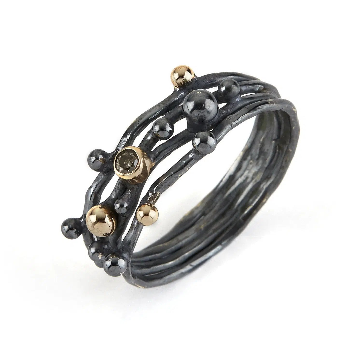 Rå og unik ByBirdie ring med en kombination af oxideret sølv og 14kt guld. Ringen er udsmykket med små guldkugler og en naturlig diamant, hvilket giver den et rustikt og sofistikeret udtryk, der skiller sig ud. Perfekt til den moderne og stilfulde kvinde.