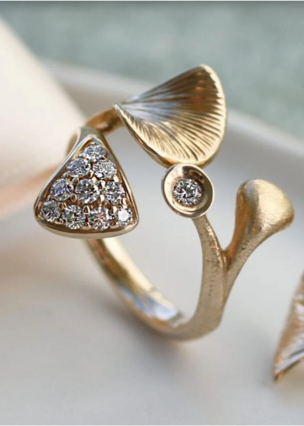 Nærbillede af guldring fra Per Borup i organisk design med brillanter og matte gulddetaljer i bløde, varme nuancer.