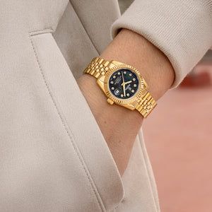 Festina F20089/3 dameur på håndled med guldfarvet lænke, sort perlemor og klassisk Swiss Made design.