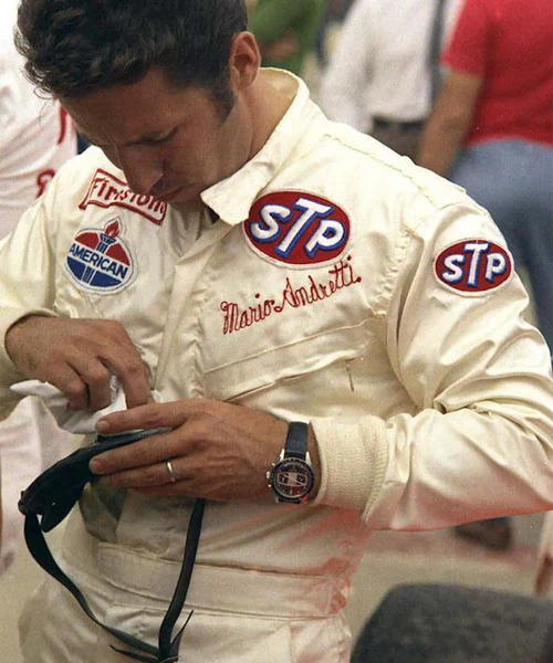 Mario Andretti iført raceroverall med STP-logo og YEMA Rallygraf-ur på håndleddet – et historisk øjeblik fra motorsportens guldalder, der viser YEMA-urets ikoniske tilknytning til racerløb.