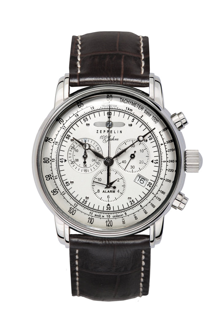  Et Zeppelin 76801 ur med en klassisk hvid urskive, detaljeret med flere underopdelinger og kronograf-funktioner. Uret har en brun læderrem med hvide syninger og en tachymeter-skala på kanten af urskiven.