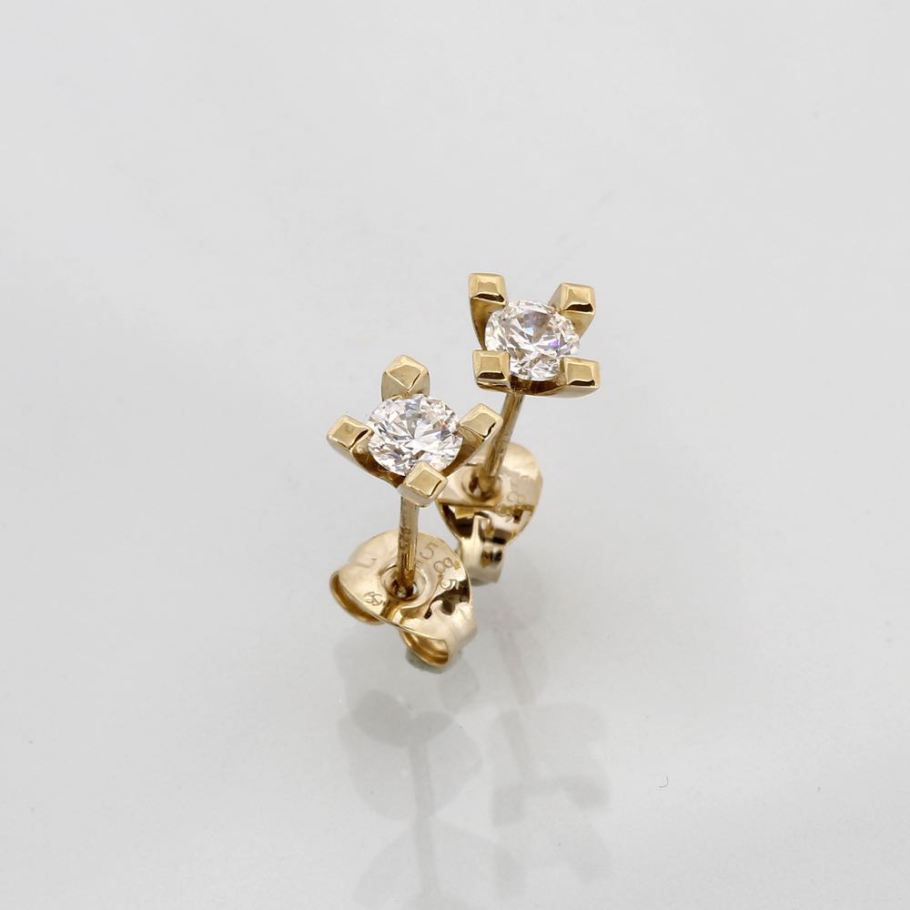 Et par elegante Jewelz ørestikker i guld, hver prydet med en strålende diamant på 0,35 ct. Disse tidløse ørestikker kombinerer luksus og enkelhed, hvilket gør dem perfekte til både hverdag og særlige lejligheder
