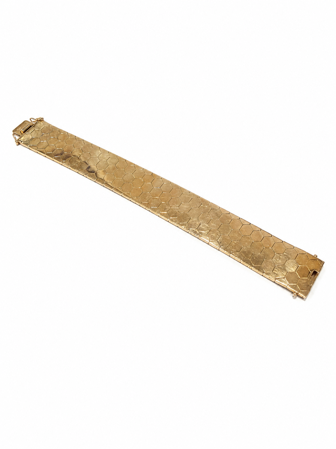 Bredt armbånd i 14 kt. guld med sekskantet mønster lagt fladt [ai-redigeret]