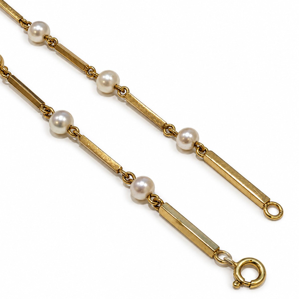 Nærbillede af fjederlås, guldpinde og hvide ferskvandsperler på brugt halskæde i 14 kt. gult guld. Kæden er 58 cm lang med perler på 4,5 mm og synlige naturlige brugsspor – 68Dame1068 [ai-redigeret]