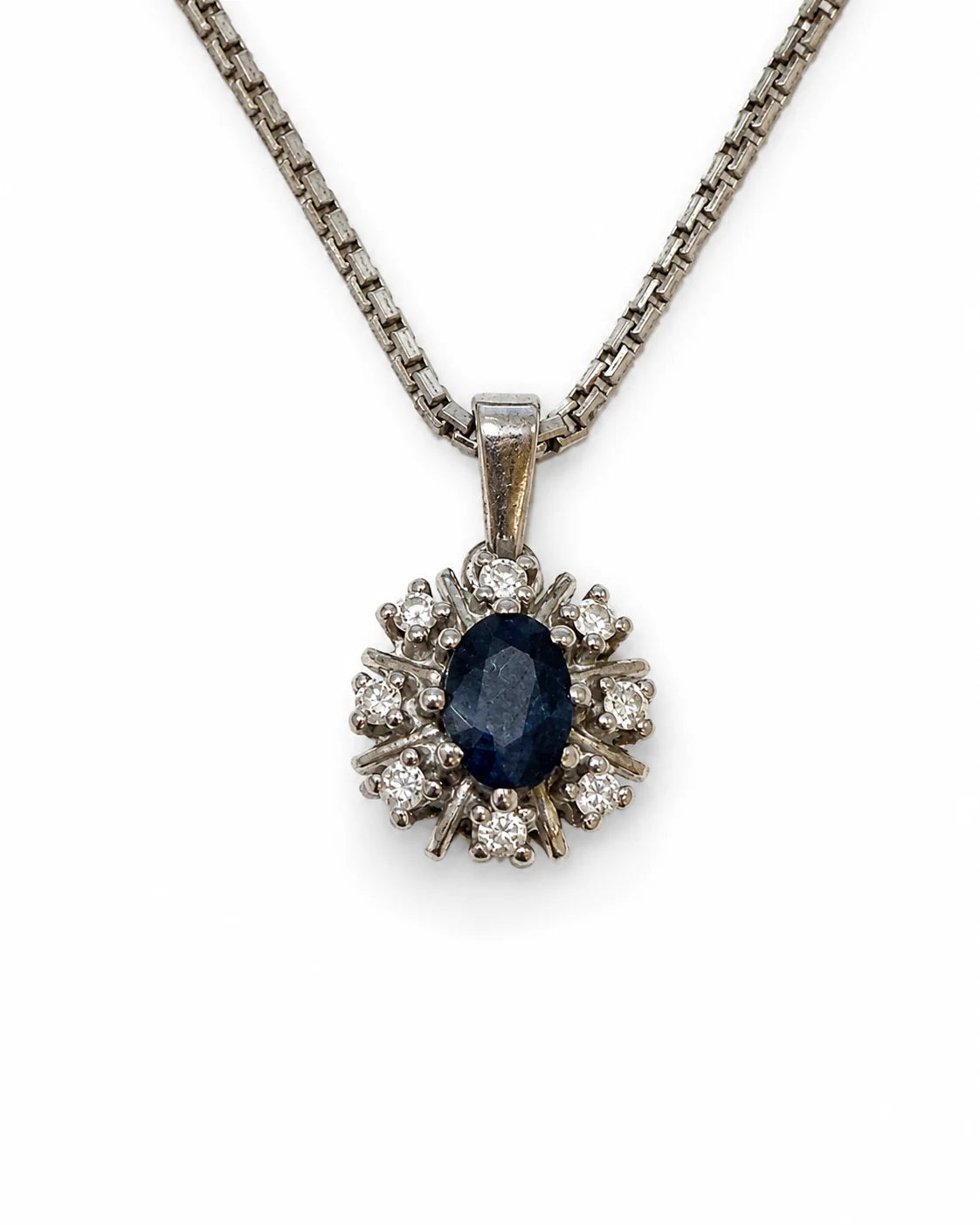 Detalje af vedhæng i 14 kt. hvidguld med oval safir og 8 diamanter [ai-redigeret]