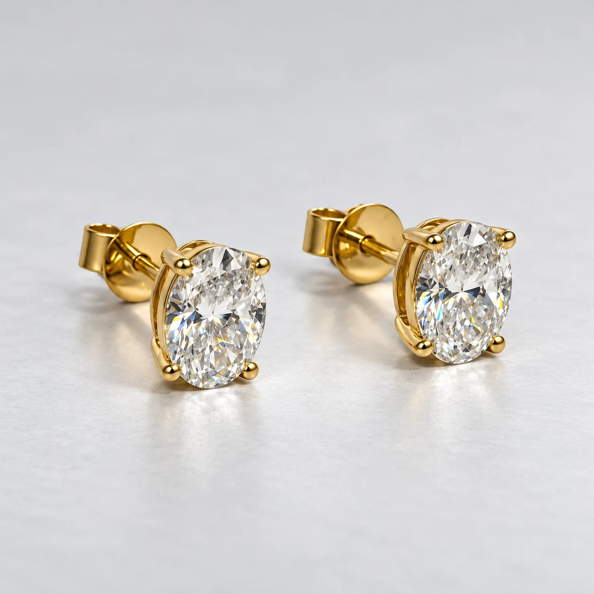 Petersen Jewels Solaris diamantøreringe i 14 kt guld med ovale labgrown diamanter i firegriberfatning, set fra siden [ai-redigeret]