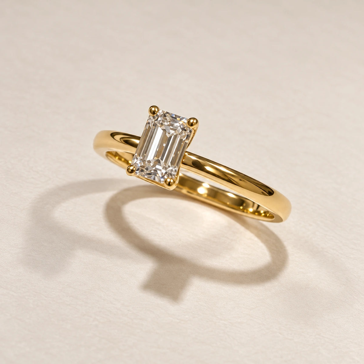 Petersen Jewels Solaris solitairering i 14 kt guld med 0,75 ct rektangulær emerald cut labgrown diamant, set fra venstre [ai-redigeret]