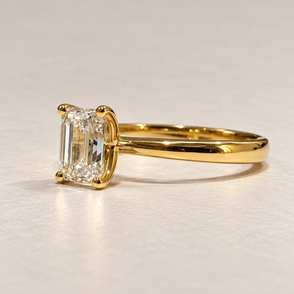 Sideprofil af Petersen Jewels Solaris guldring i 14 kt med 1,00 ct smaragdslibet labgrown diamant i klassisk firegriberfatning [ai-redigeret]