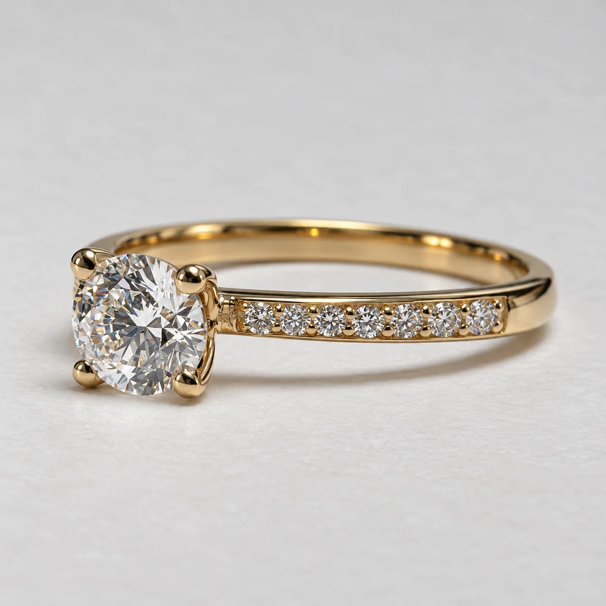 Detaljebillede af Petersen Jewels guldring i 14 kt guld med rund labgrown diamant på 0,75 ct og funklende sidesten [ai-redigeret]