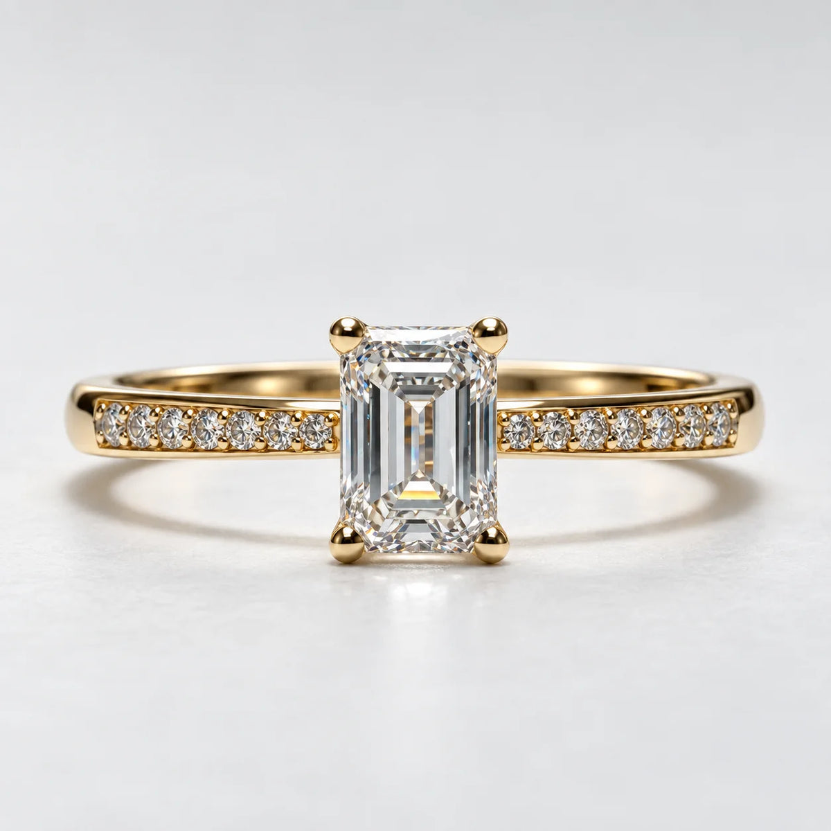 Petersen Jewels solitairering i 14 kt guld med 0,75 ct smaragdslibet labgrown centerdiamant og syv små diamanter på hver side, forfra [ai-redigeret]