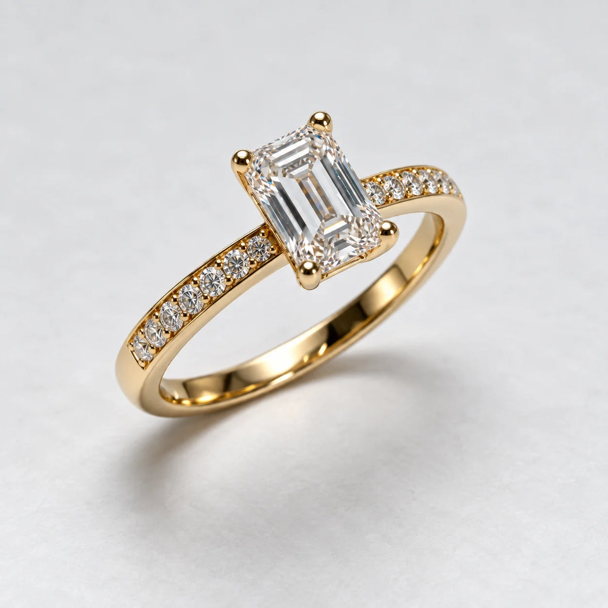 Petersen Jewels 14 kt guldring med 0,75 ct smaragdslibet labgrown diamant og små sidesten, set fra skrå vinkel [ai-redigeret]
