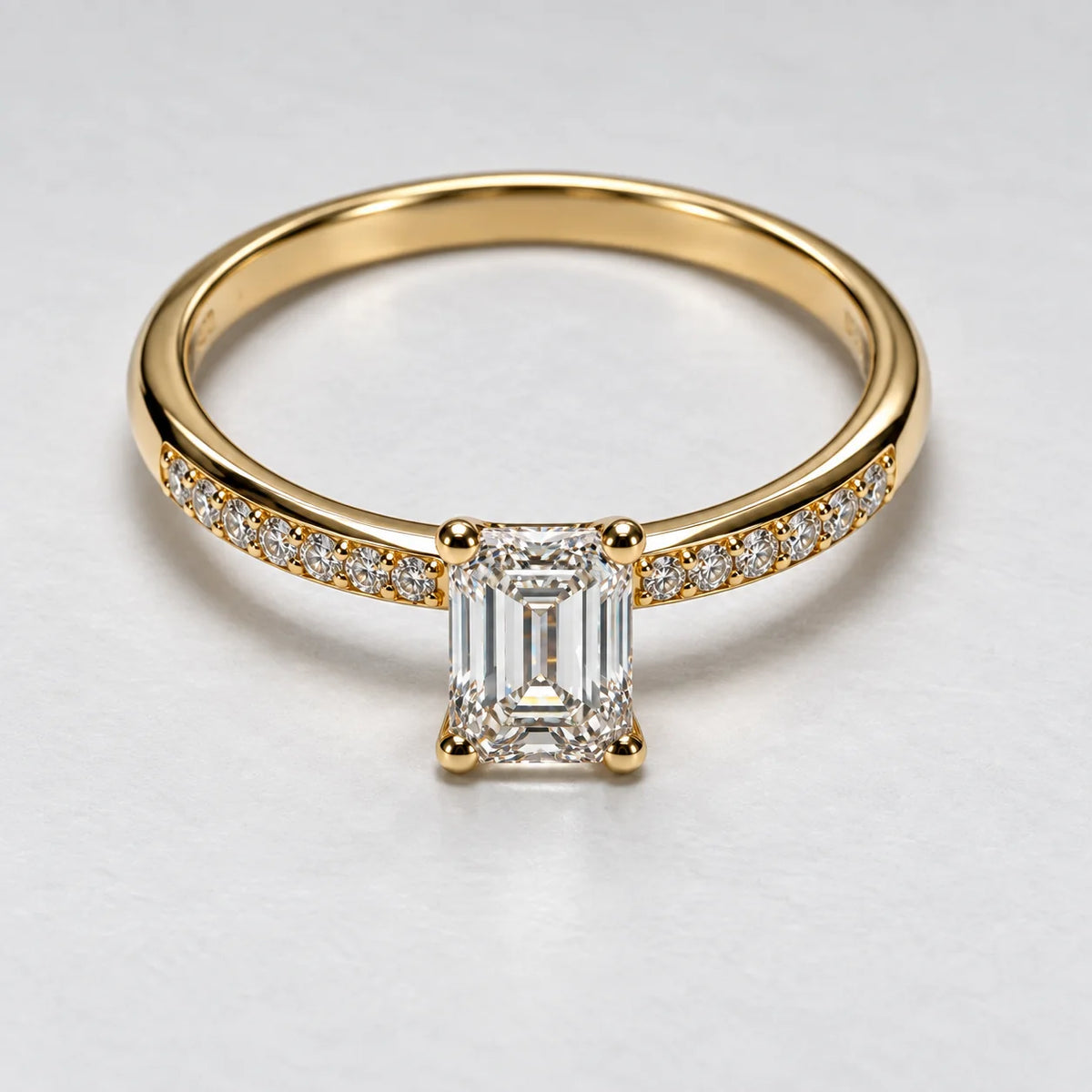 Petersen Jewels diamantring i 14 kt guld med smaragdslibet centerdiamant på 0,75 ct og syv sidesten på hver side, set oppefra [ai-redigeret]
