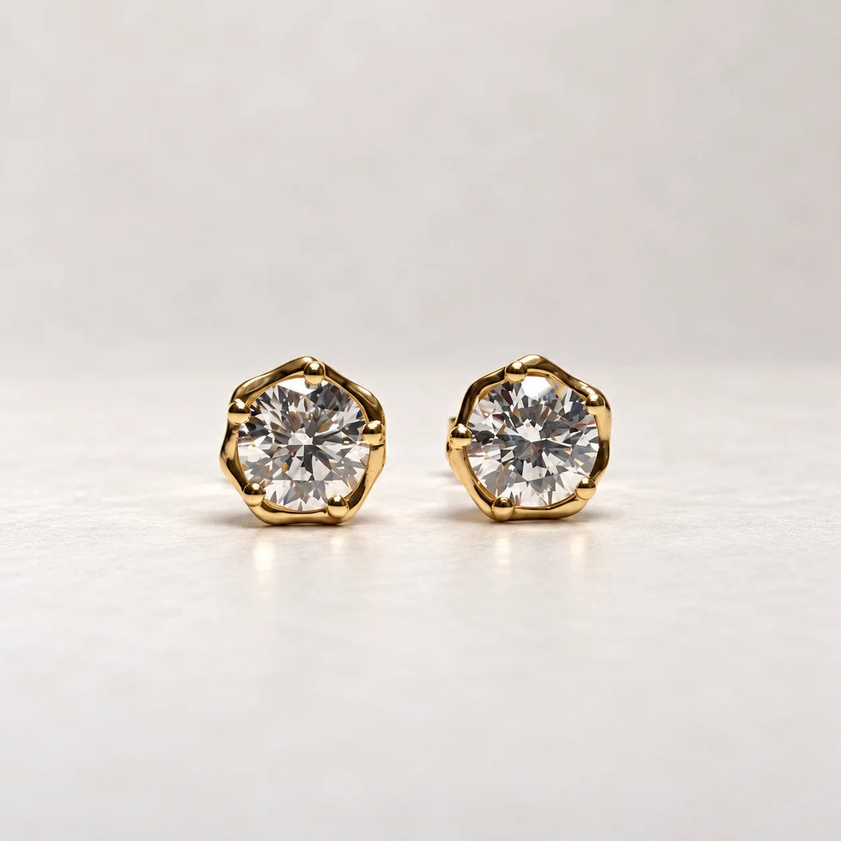 Rustikke diamantørestikker fra Petersen Jewels Stella i blankt 14 kt guld, skrå visning af guldfatning og sten [ai-redigeret]