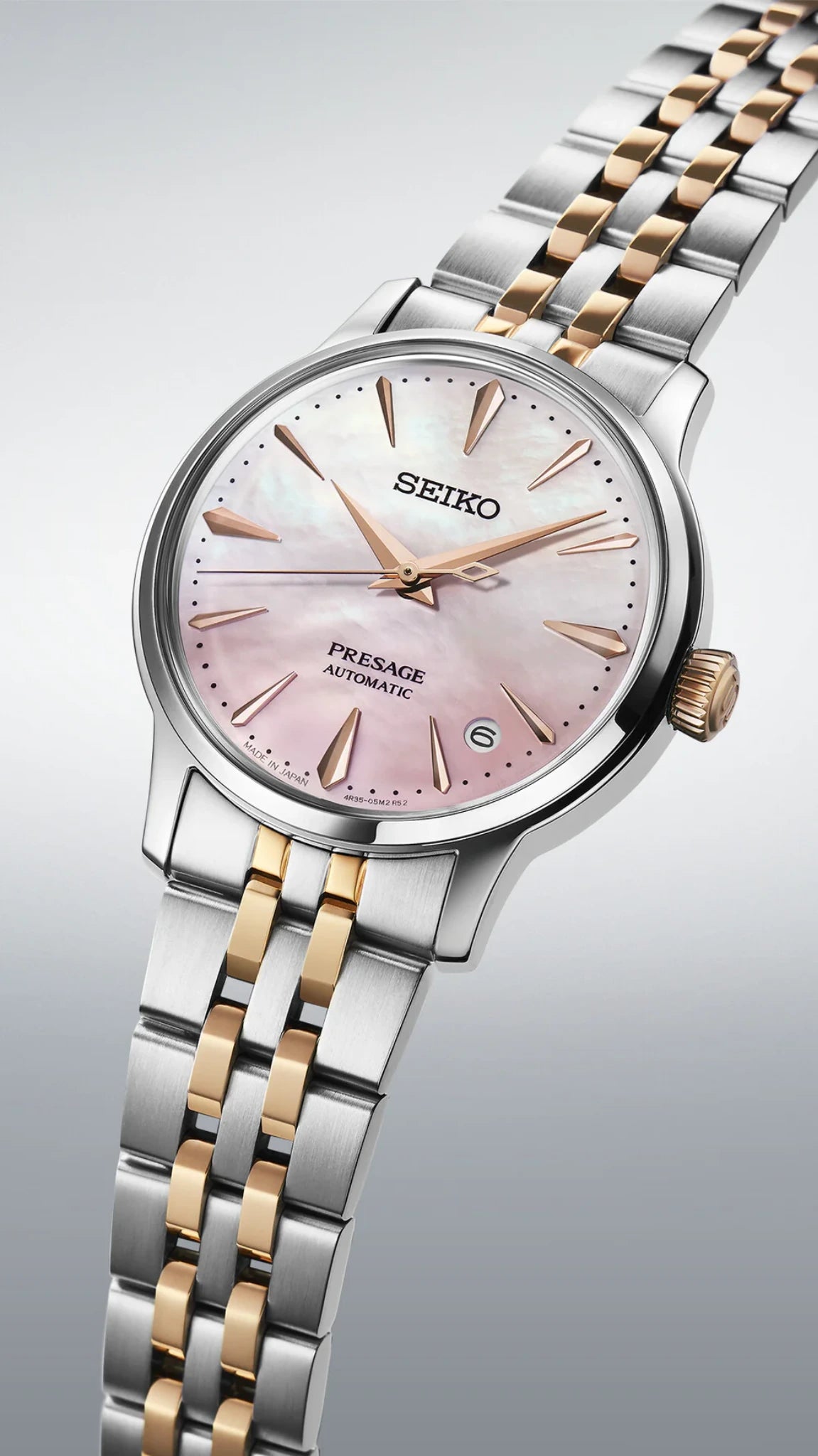 Seiko Presage Cocktail SRPM06J1 dameur i skrå vinkel med rosa perlemorsskive, guldfarvede visere og elegant tofarvet stållænke