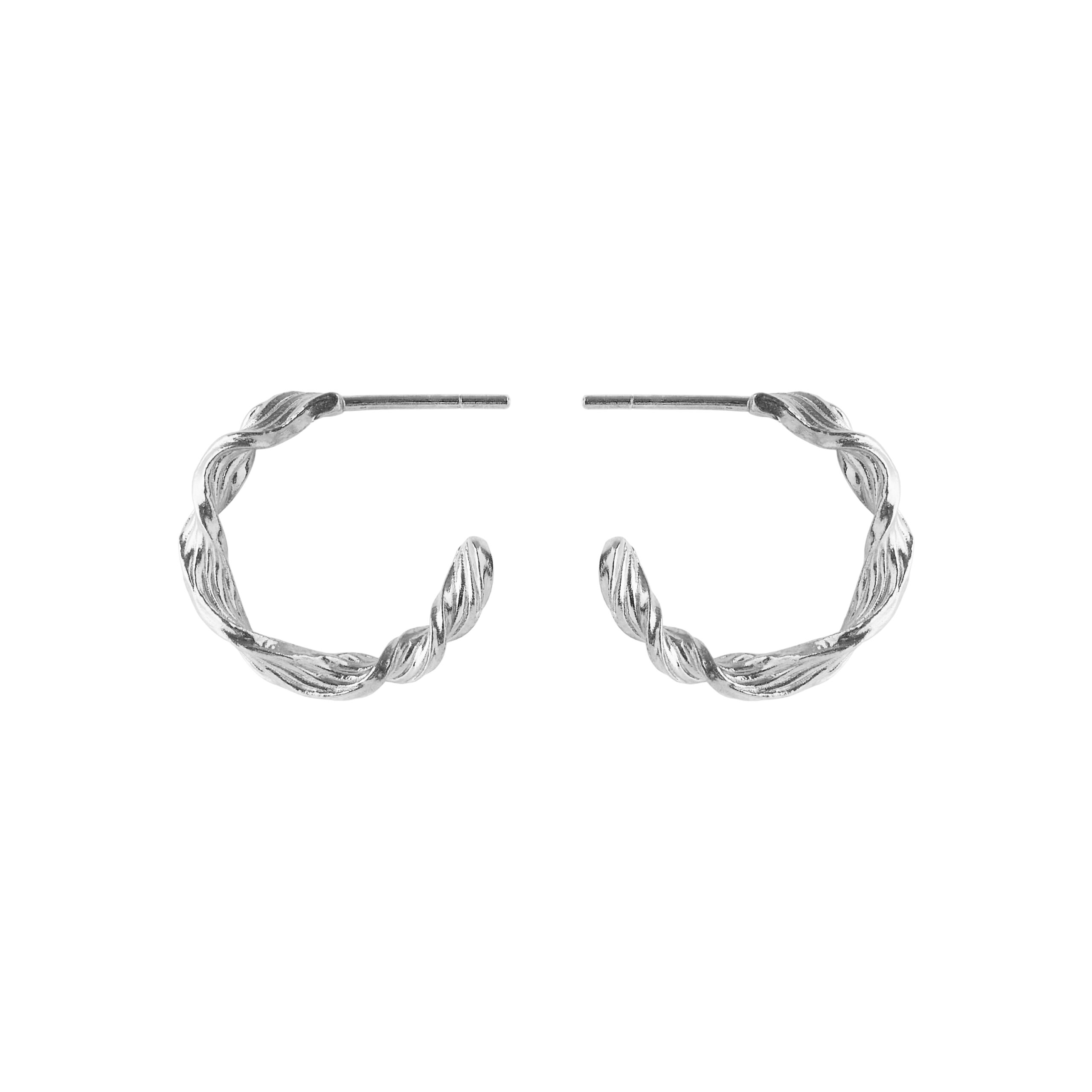 Pernille Corydon præsenterer de elegante Dancing Wave Hoops, der er inspireret af havets rolige bevægelser. Disse øreringe har et enkelt og unikt design med en smukt snoet form og er tilgængelige i to størrelser. Fremstillet med certificeret genbrugssølv fås de både i sølv og forgyldt sølv, og de måler 20 mm i diameter.
